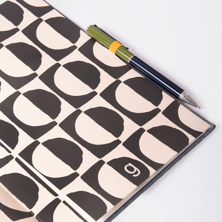 Notebook internal page with geometric pattern and pen on a white background