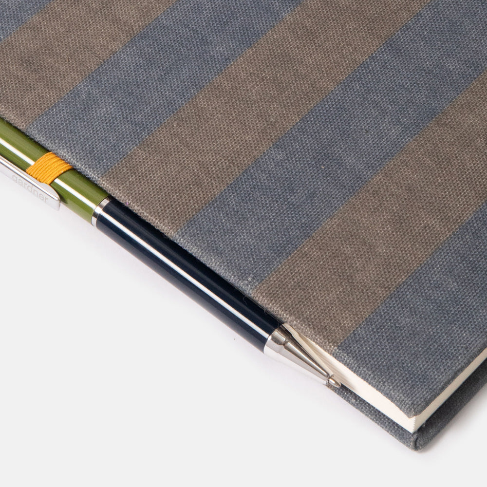 khaki and navy blue striped notebook & pen set on a white background