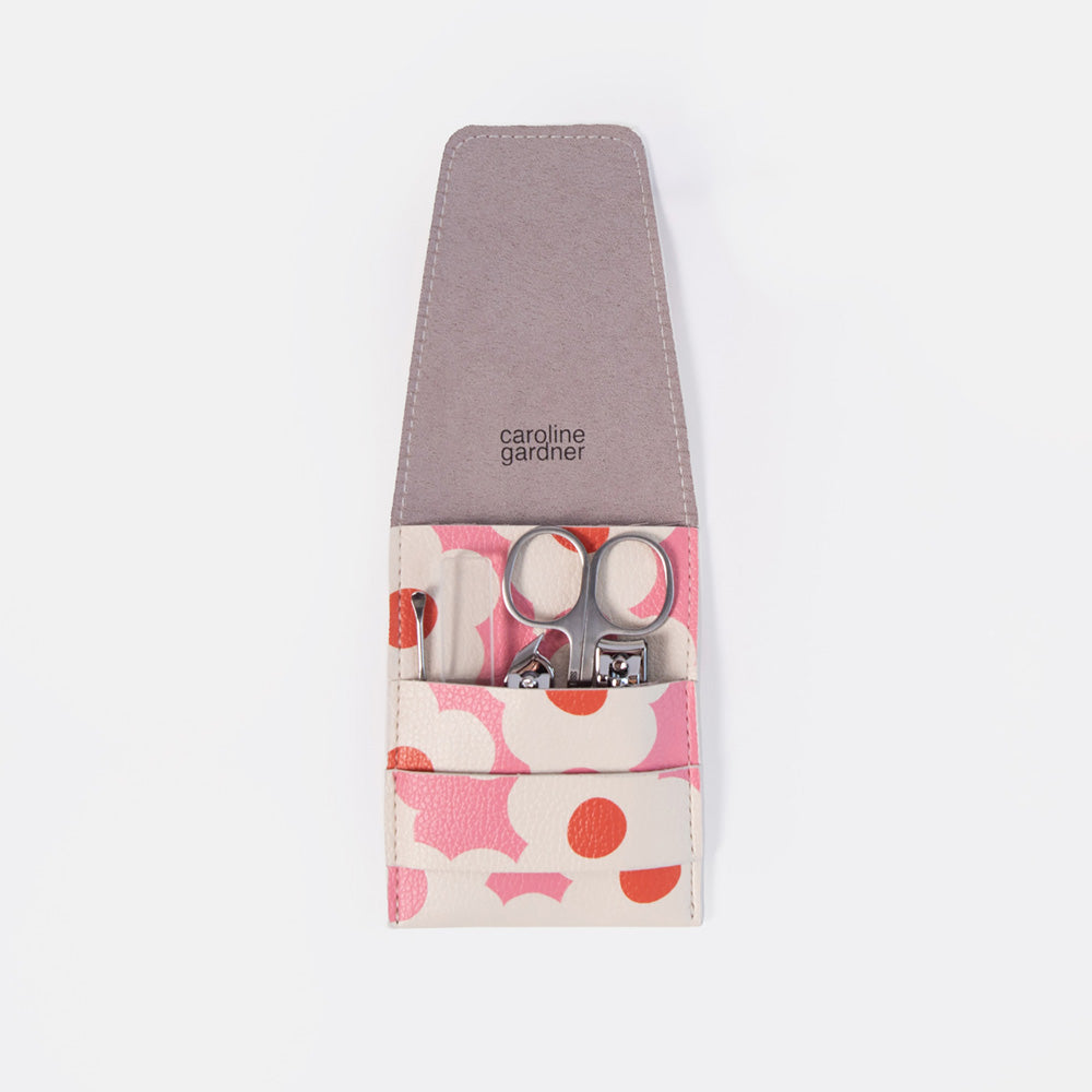A Caroline Gardiner nail care set in a zippered pouch with a dusty purple interior and a pink, white, and orange floral patterned exterior. The pouch is shown open, revealing silver nail scissors and nail clippers inside, set against a plain white background.