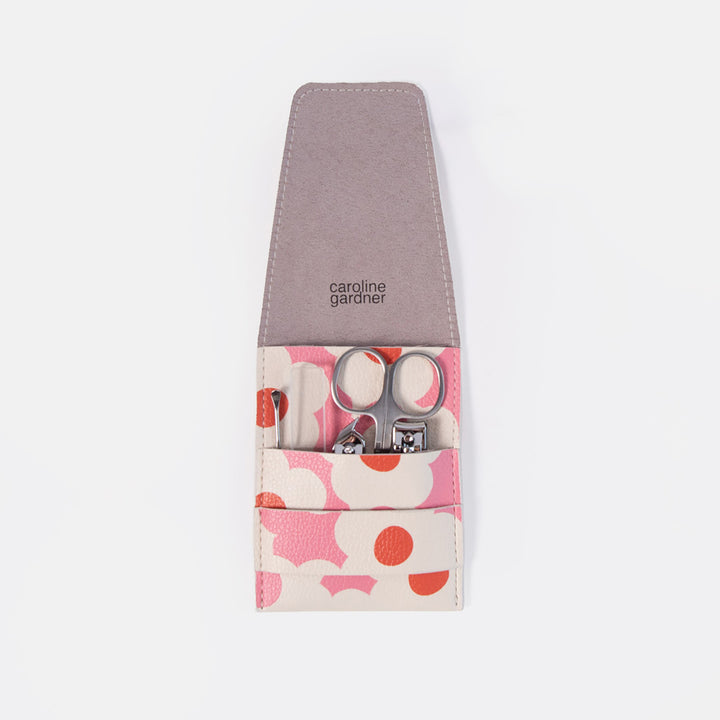A Caroline Gardiner nail care set in a zippered pouch with a dusty purple interior and a pink, white, and orange floral patterned exterior. The pouch is shown open, revealing silver nail scissors and nail clippers inside, set against a plain white background.