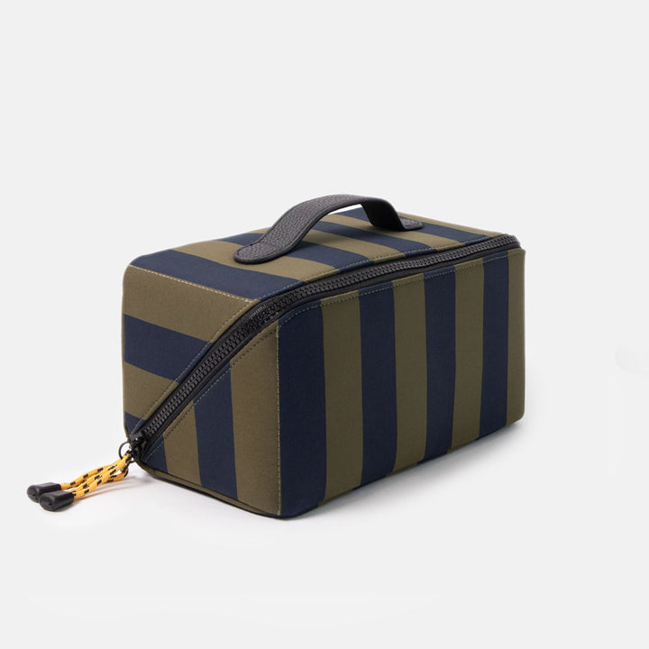 blue and green striped wash bag with black zip, yellow zip pulls and black top grab handle on a white background