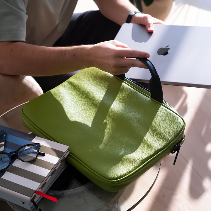 moss green vegan leather laptop bag with retro stripe lining in orange, green, brown, blue & black