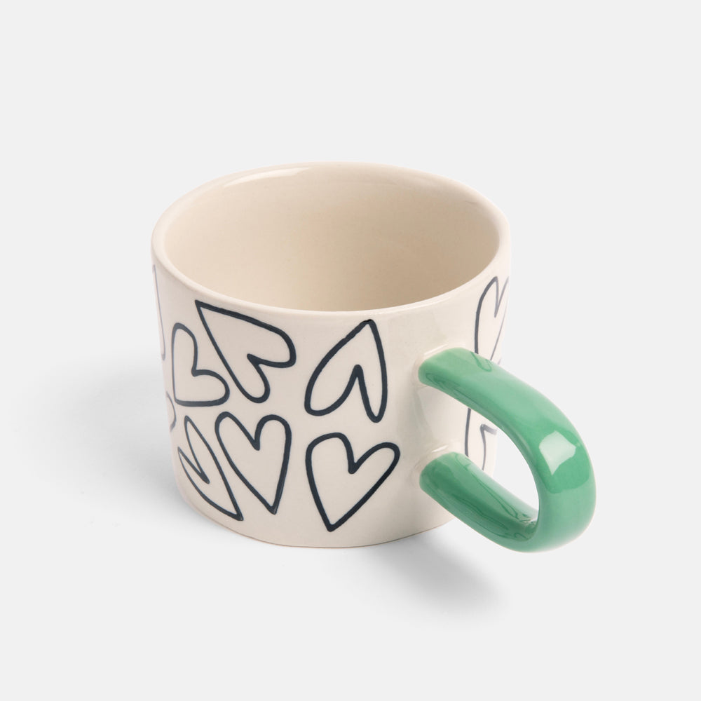 monochrome hearts hand painted stoneware mug with contrast green handle