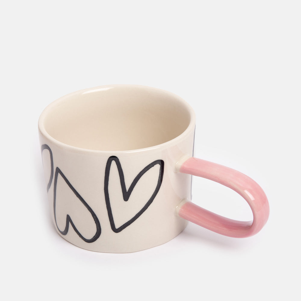 hand painted ceramic stoneware mug with monochrome hearts design and pale pink elongated handle