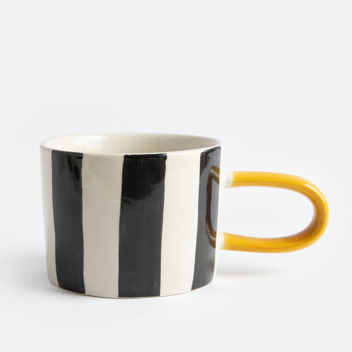 hand painted ceramic stoneware mug with black stripes design and a mustard elongated handle