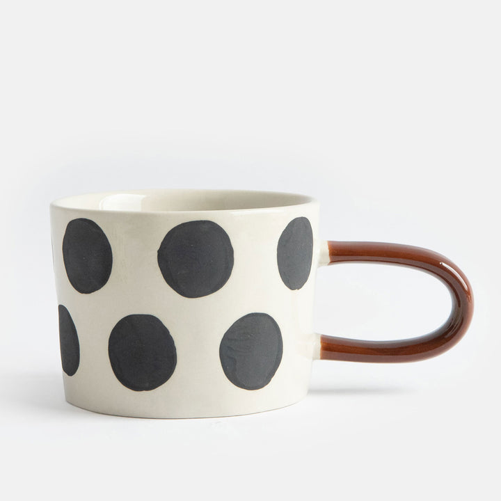 hand painted ceramic stoneware mug with big black dots design and a brown elongated handle