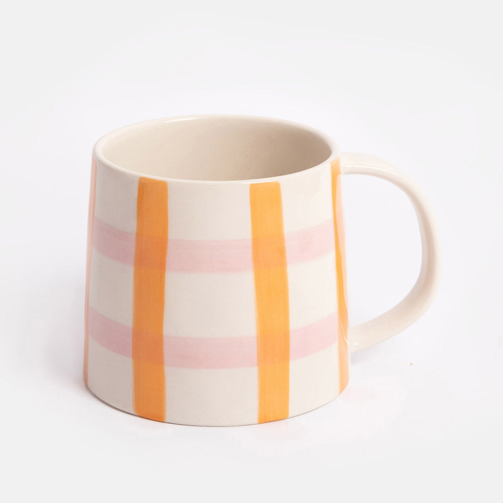 mug with a pink and orange check design on a light grey background