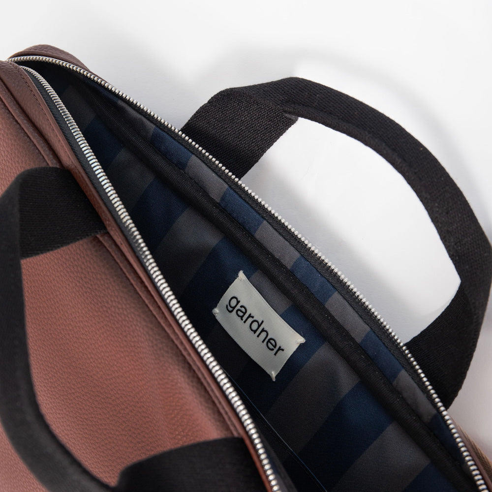 dark purple leather look laptop bag with black grab handles and blue & khaki stripe internal lining 