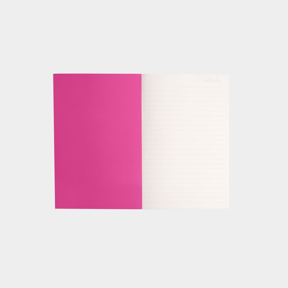 internal shot of notebook with bright pink inside cover and white lined page