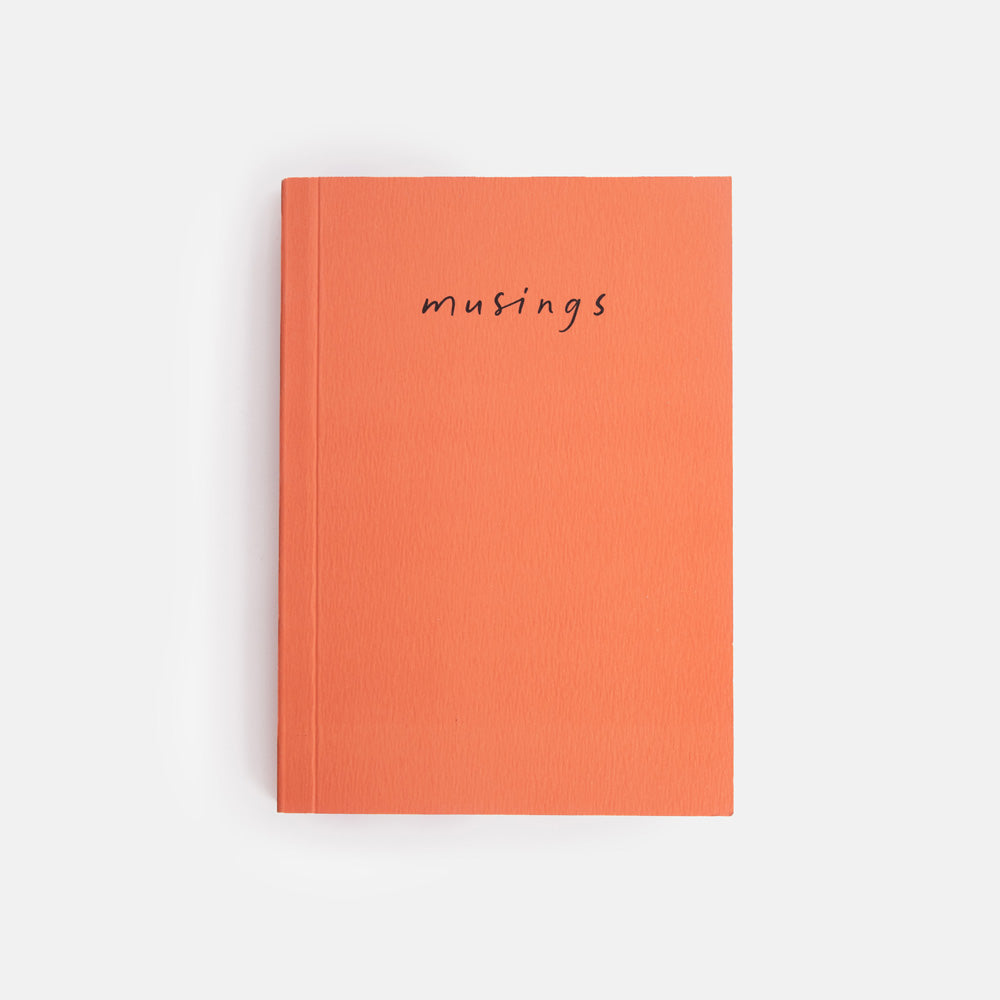 Orange notebook with 'musings' text on a white background