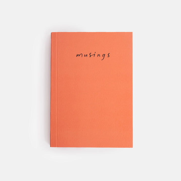 Orange notebook with 'musings' text on a white background