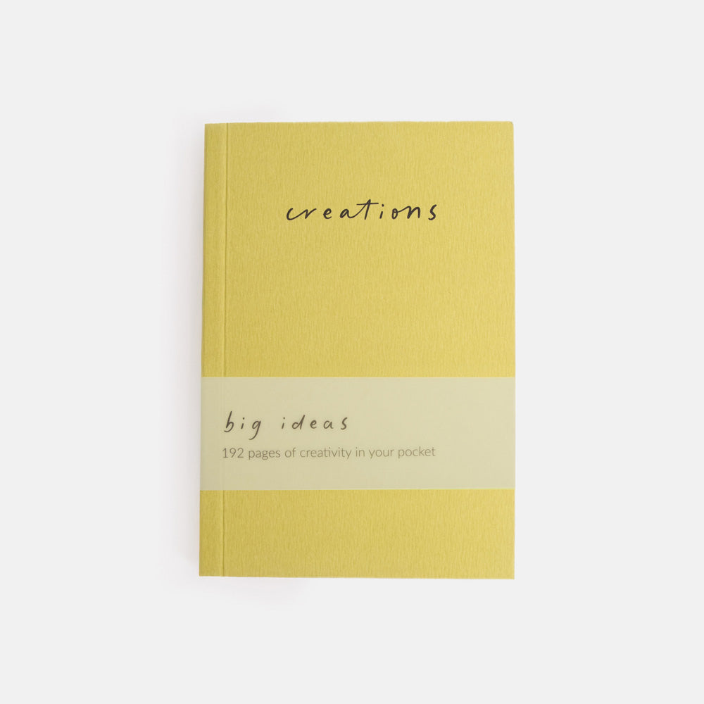green notebook with 'creations' and 'big ideas' text on a white background