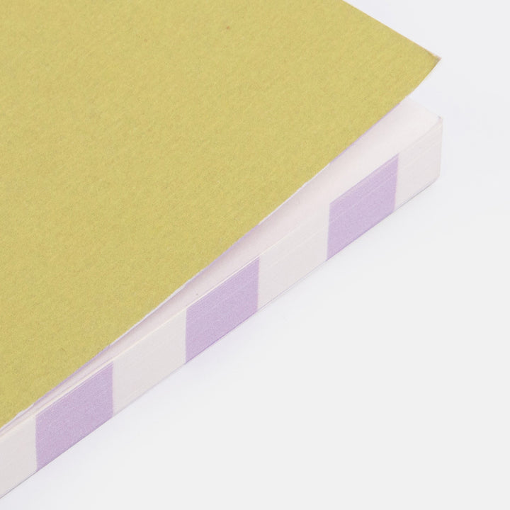 close up of a green notebook with lilac stripe page edges
