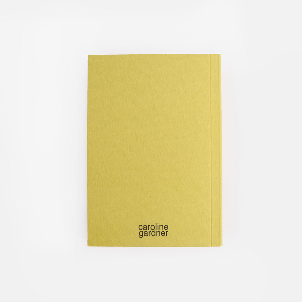 green notebook with 'caroline gardner' branding on a white background