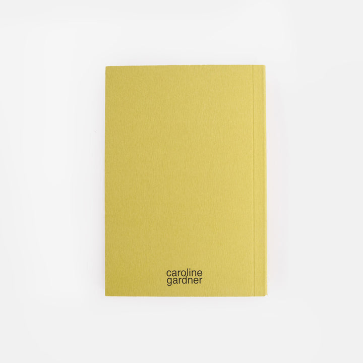 green notebook with 'caroline gardner' branding on a white background