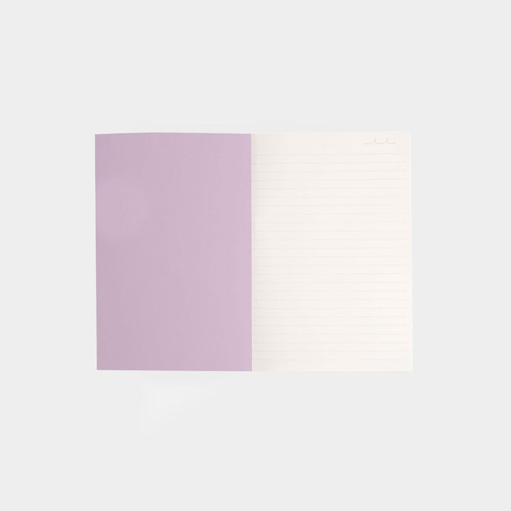 inside cover of a notebook with a lilac page and a white lined page