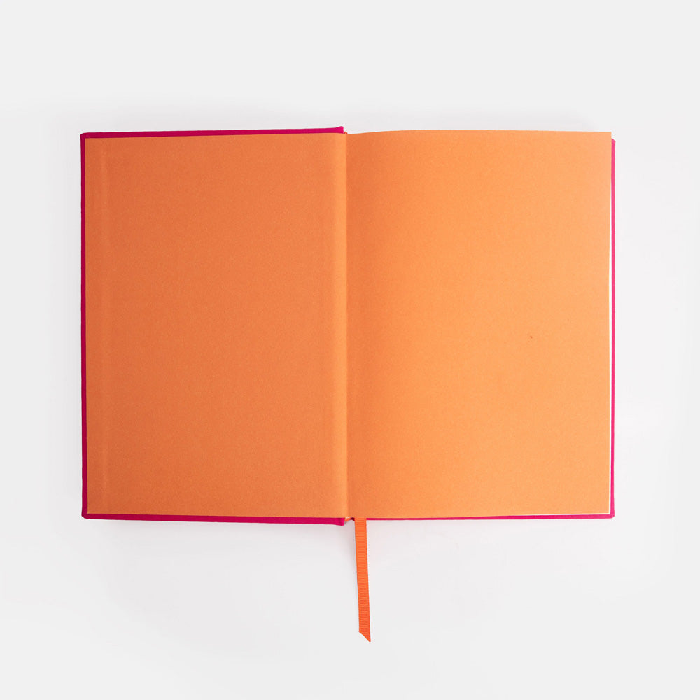Open notebook with orange cover and pink spine on a white background