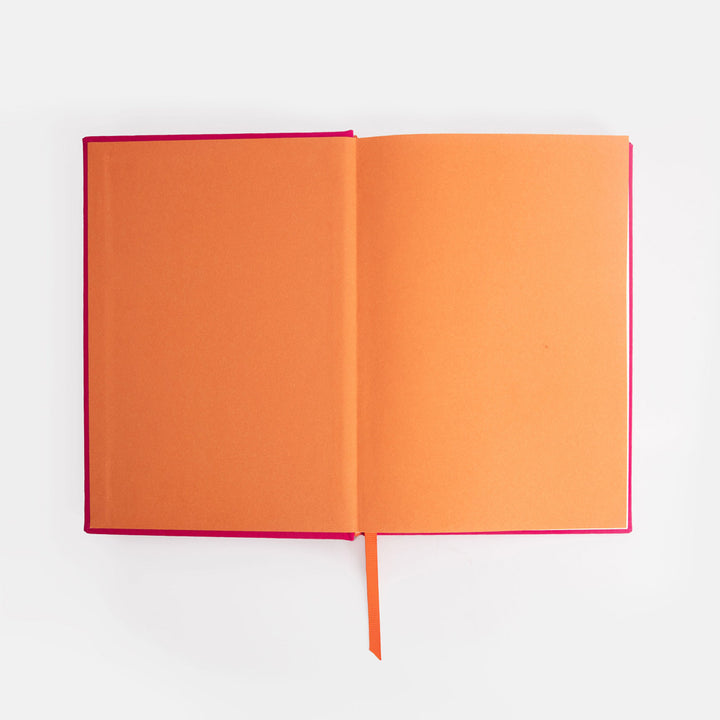Open notebook with orange cover and pink spine on a white background
