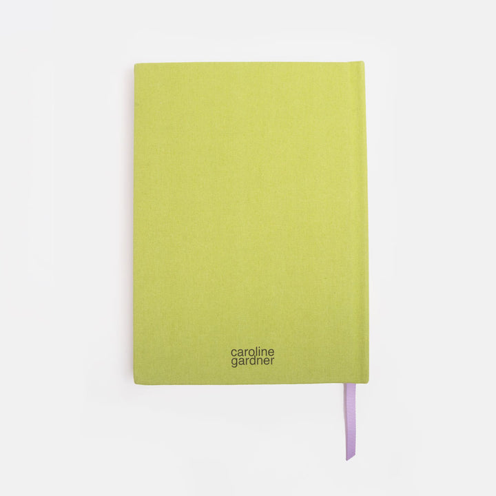 Green notebook with 'caroline gardner' branding on a white background