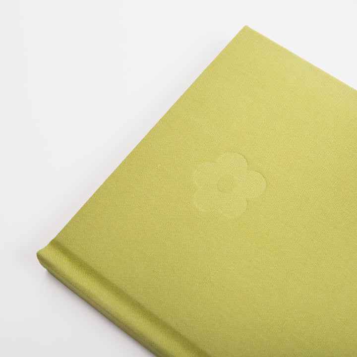 Green fabric notebook with a debossed flower design on a white background