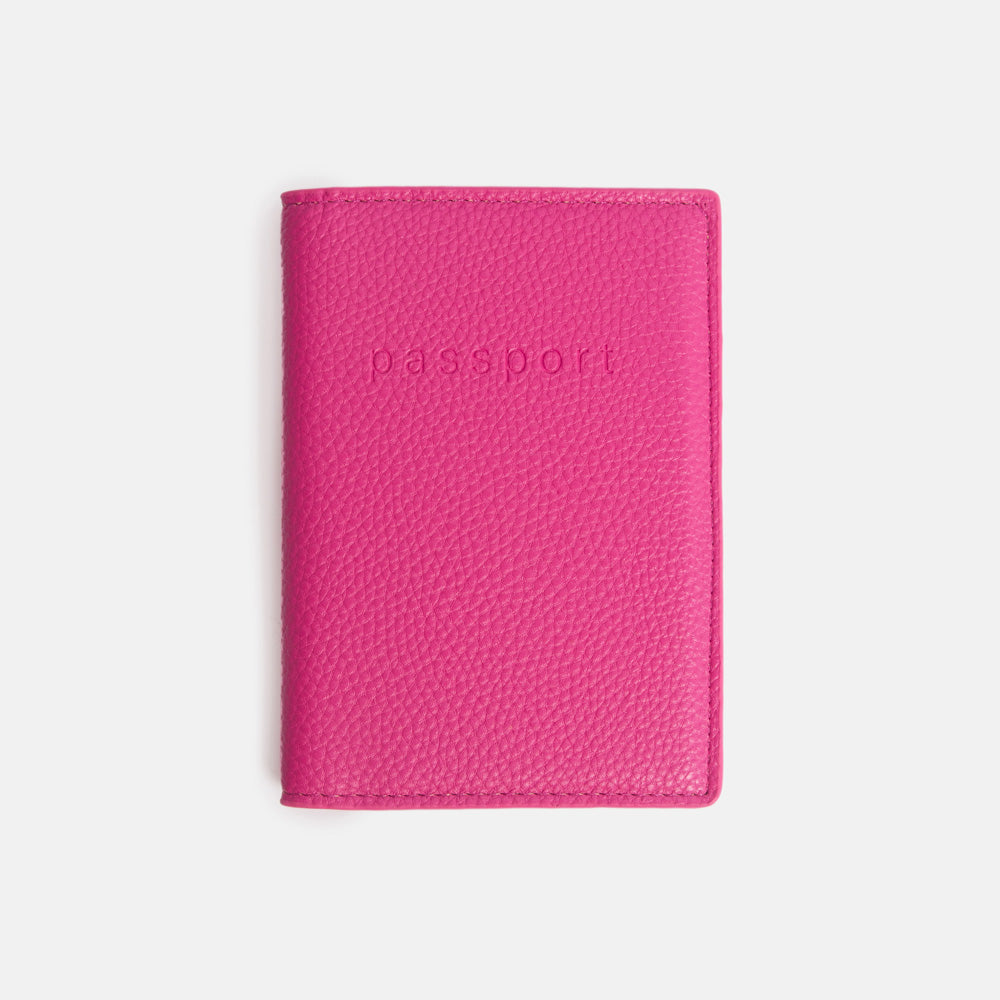 bright pink leather look passport holder with the word 'passport' debossed