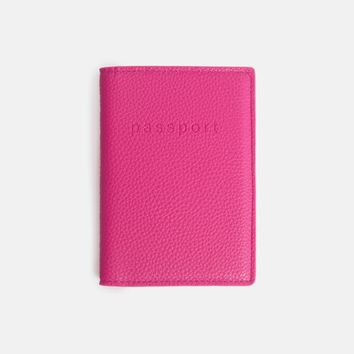 bright pink leather look passport holder with the word 'passport' debossed