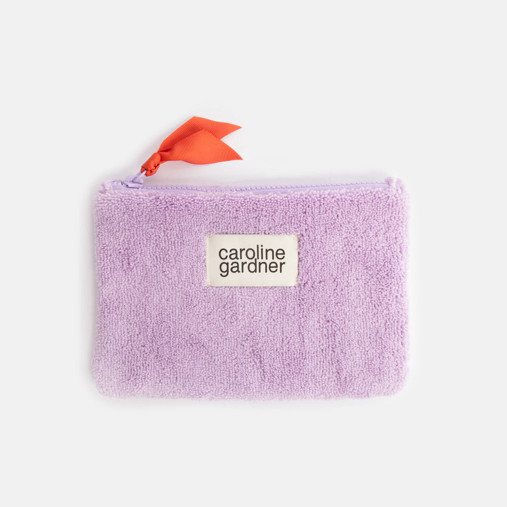 lilac towelling zip close pouch with orange zip pull and 'caroline gardner' branded tab