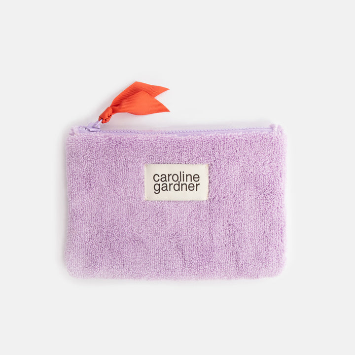 lilac towelling zip close pouch with orange zip pull and 'caroline gardner' branded tab