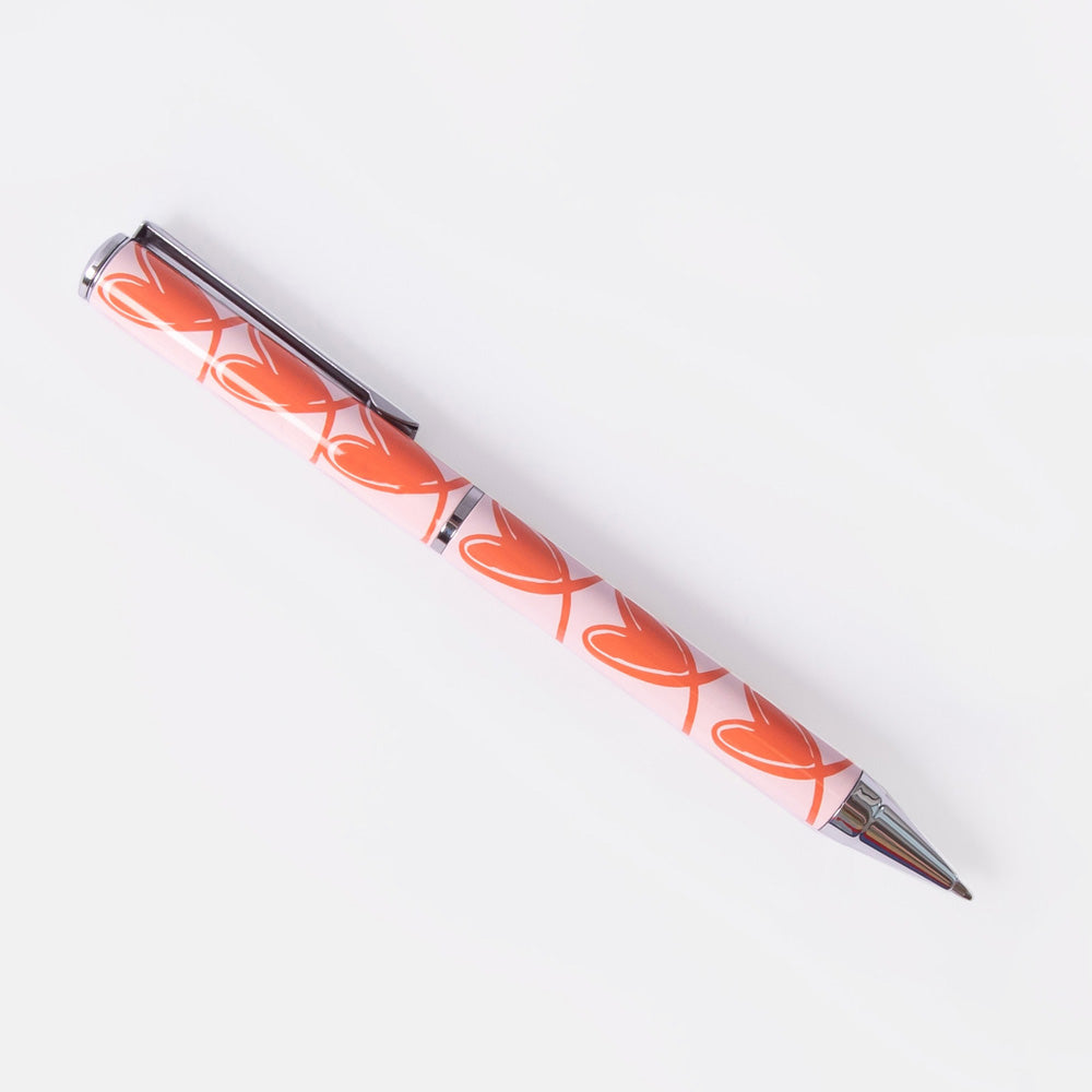 ballpoint pen with orange looped hearts on a pink background
