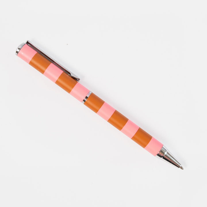A striped pen with alternating pink and brown bands, featuring a silver metal clip and tip, photographed diagonally on a clean white background.