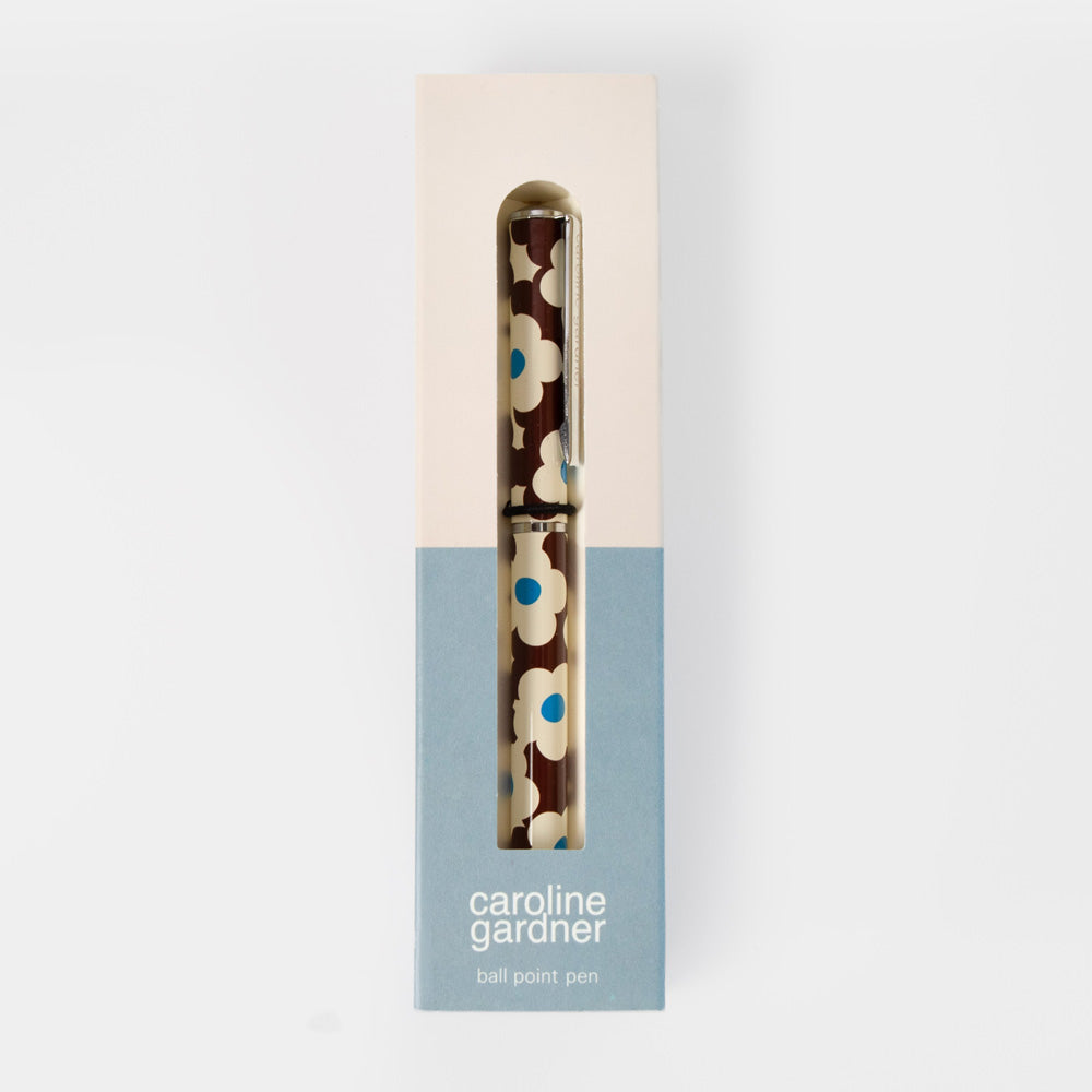 A Caroline Gardner ball point pen with a brown, cream, and blue floral pattern, presented in its original packaging box against a light gray background.