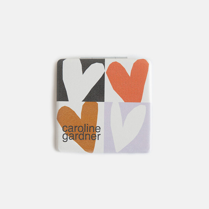printed leather look PU square compact pocket mirror in a multi coloured hearts print, with 2 mirrors and magnetic fastening