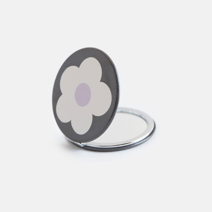 printed leather look PU round compact pocket mirror in a cream flower over charcoal print, with 2 mirrors and magnetic fastening
