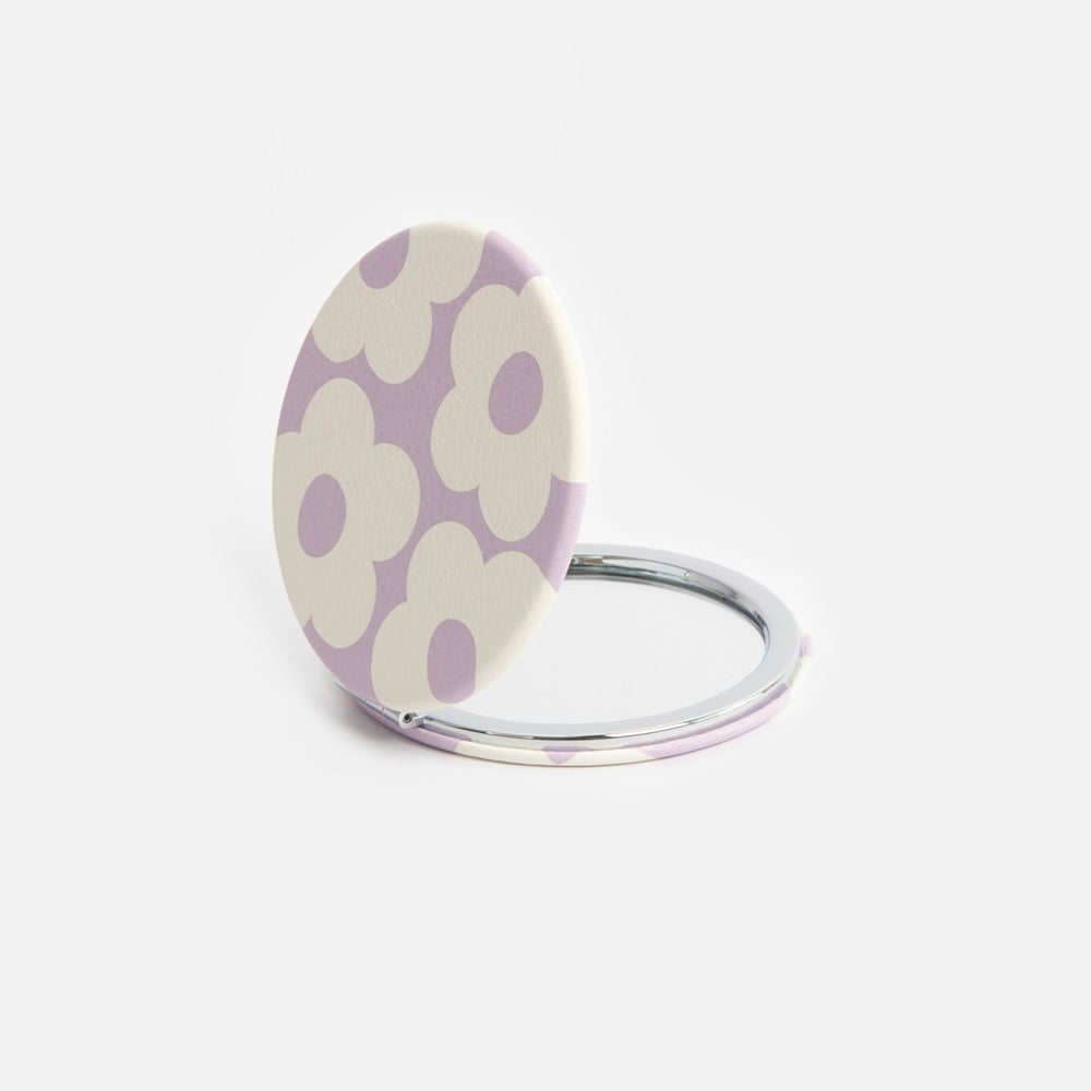 Compact mirror with purple floral design on a white background