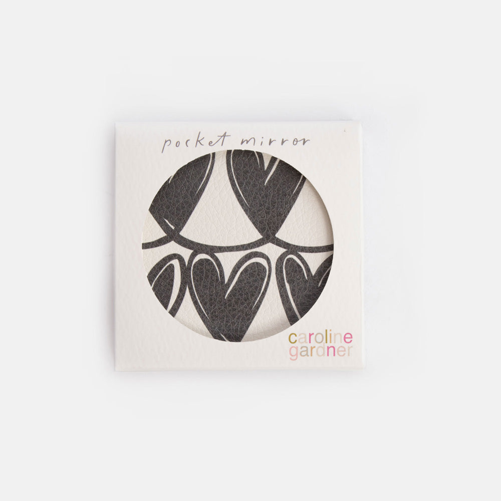 Pocket mirror with black heart design in a white box, branded 'caroline gardner'.