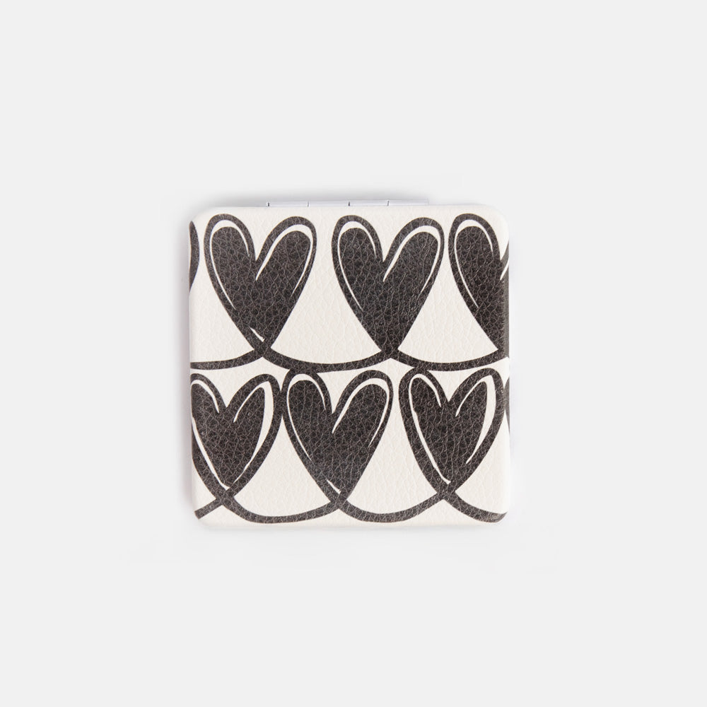 Square compact mirror with black heart pattern on a white background
