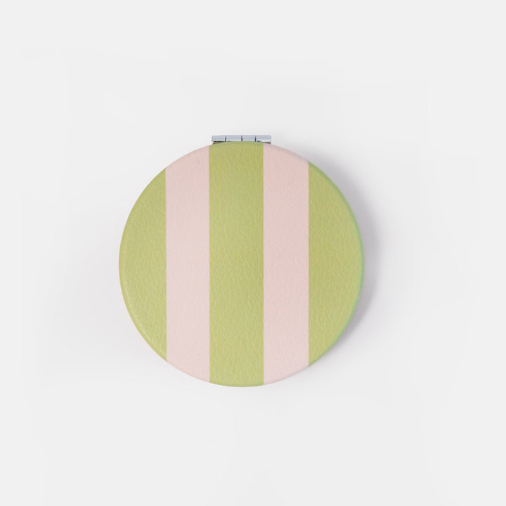 A round compact mirror with a pastel green and pink striped pattern, shown closed on a clean white background.