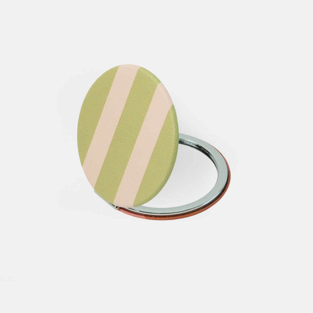 A compact oval mirror with a green and pale pink striped cover, shown open to reveal a silver metal ring stand, on a clean white background.