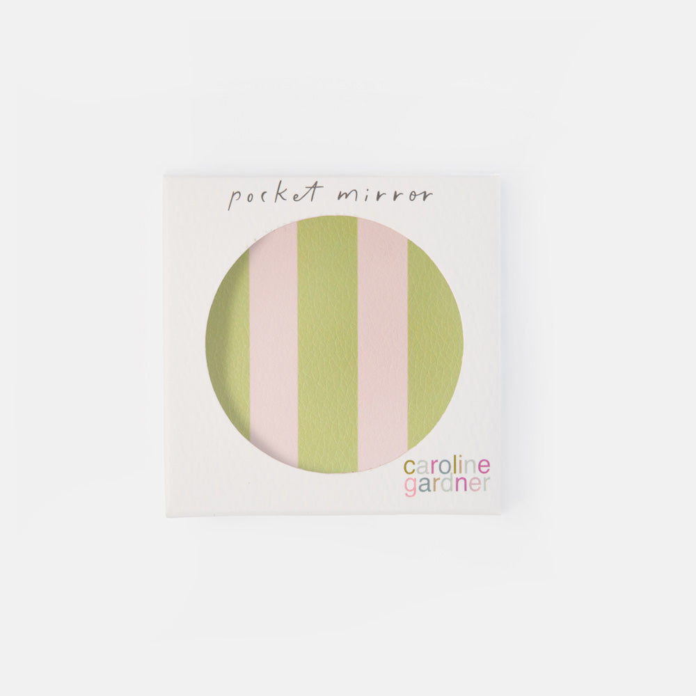A square white product box with a circular cutout showing pastel vertical stripes in light green and pink. Handwritten text at the top reads 'pocket mirror,' and the brand name 'caroline gardiner' appears at the bottom right.