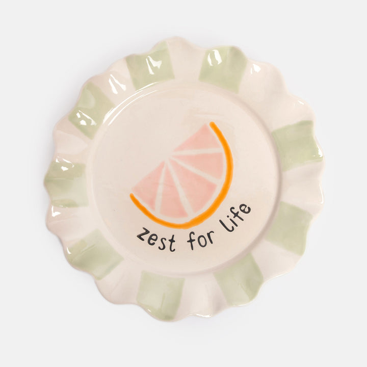 hand painted ceramic stoneware plate with green stripe scalloped edge and grapefruit slice design and 'zest for life' slogan