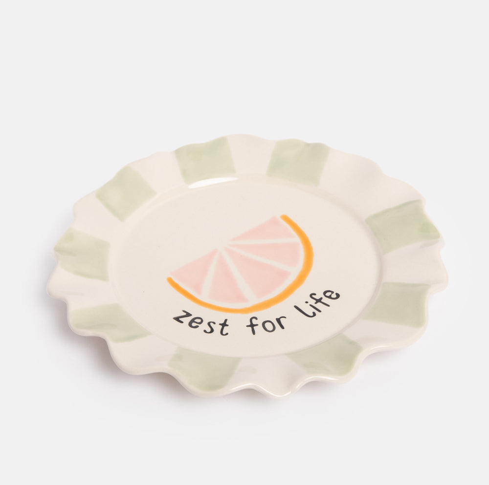 hand painted ceramic stoneware plate with green stripe scalloped edge and grapefruit slice design and 'zest for life' slogan