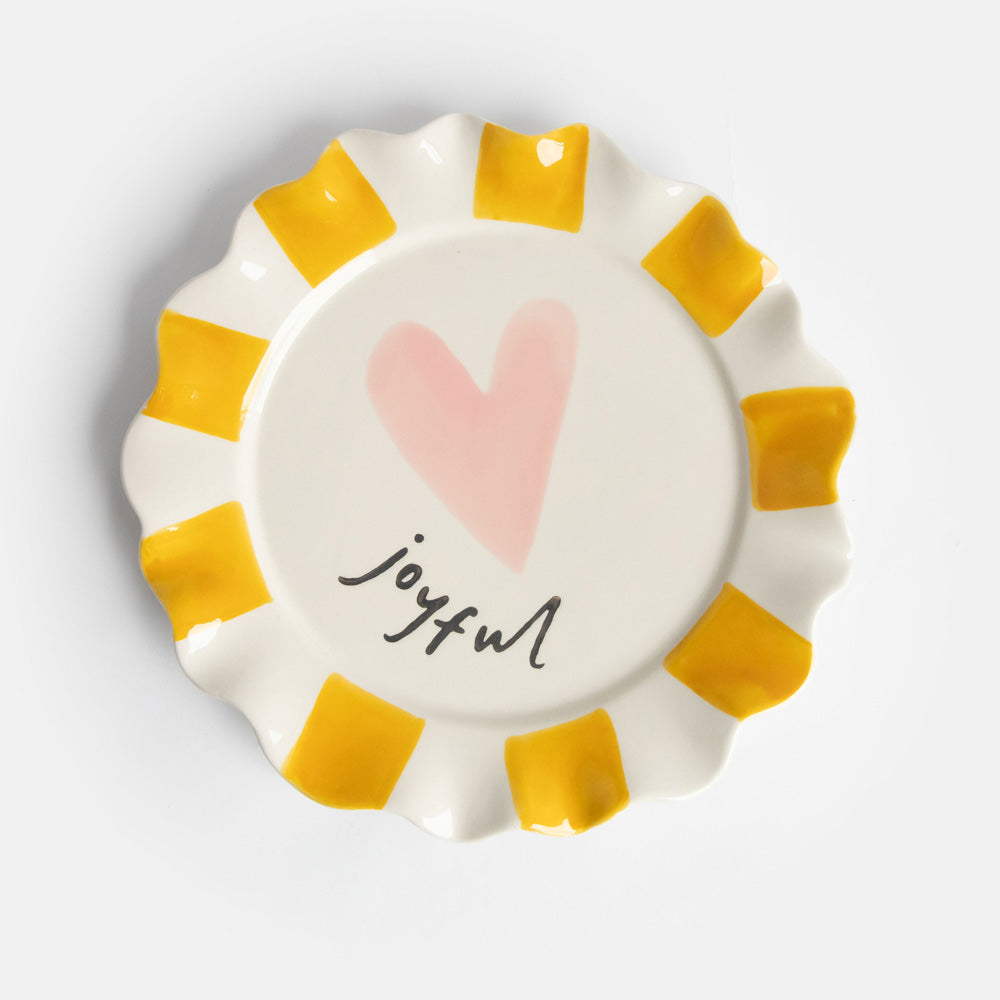 ceramic stoneware plate with hand painted mustard stripe scalloped edges, pink heart and "joyful" slogan  