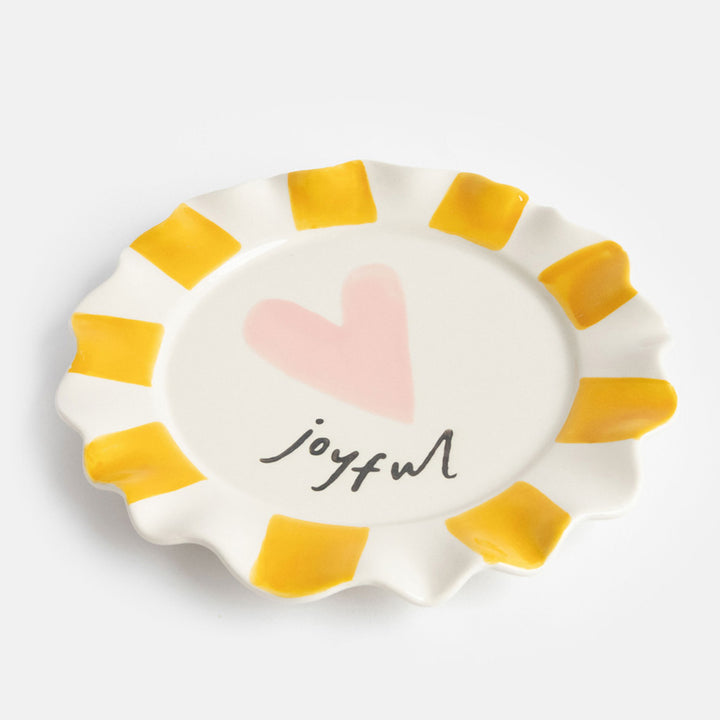 ceramic stoneware plate with hand painted mustard stripe scalloped edges, pink heart and "joyful" slogan  