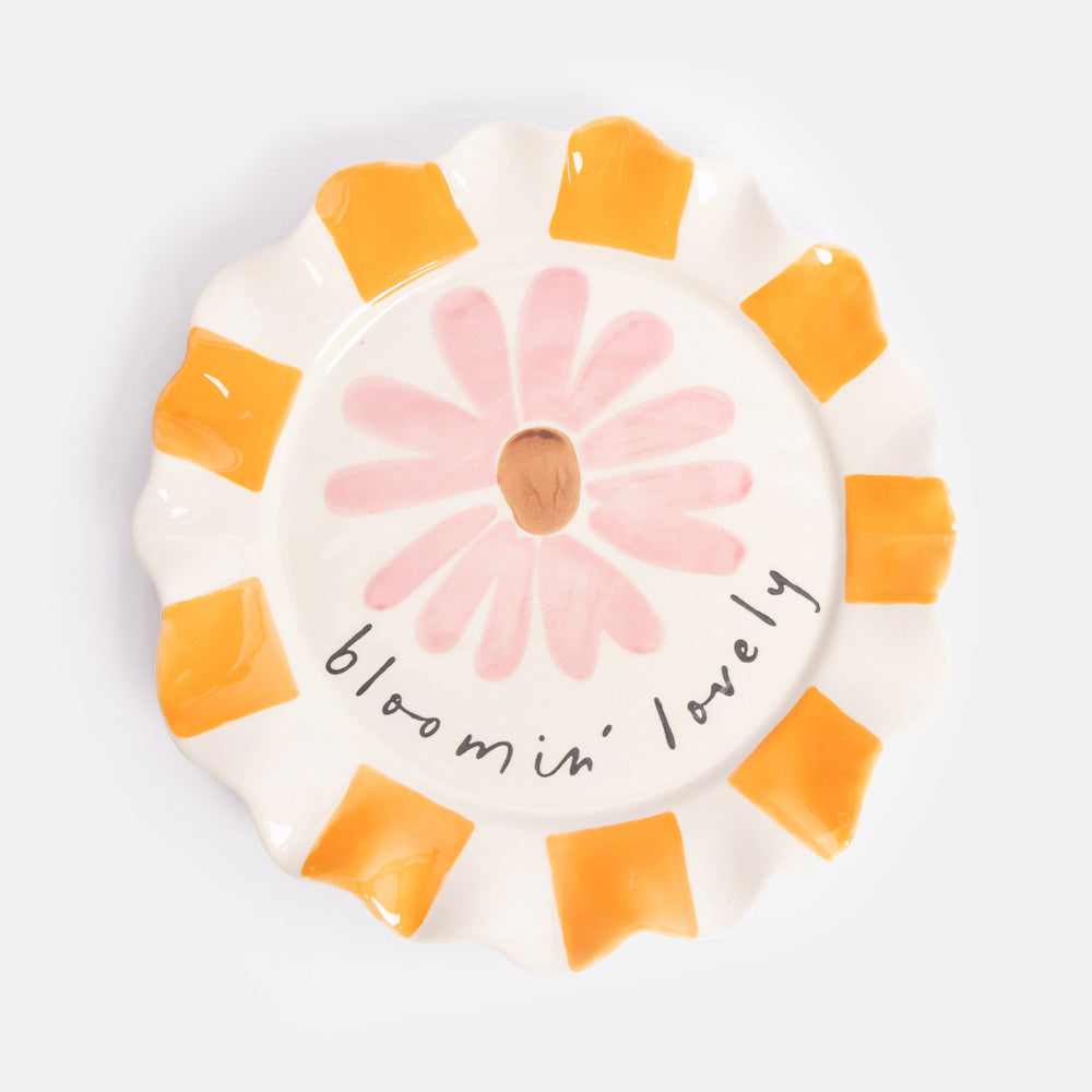 Ceramic plate with a pink flower illustration and 'bloomin' lovely' text on a white background