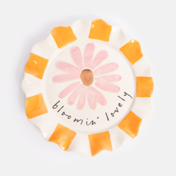 Ceramic plate with a pink flower illustration and 'bloomin' lovely' text on a white background