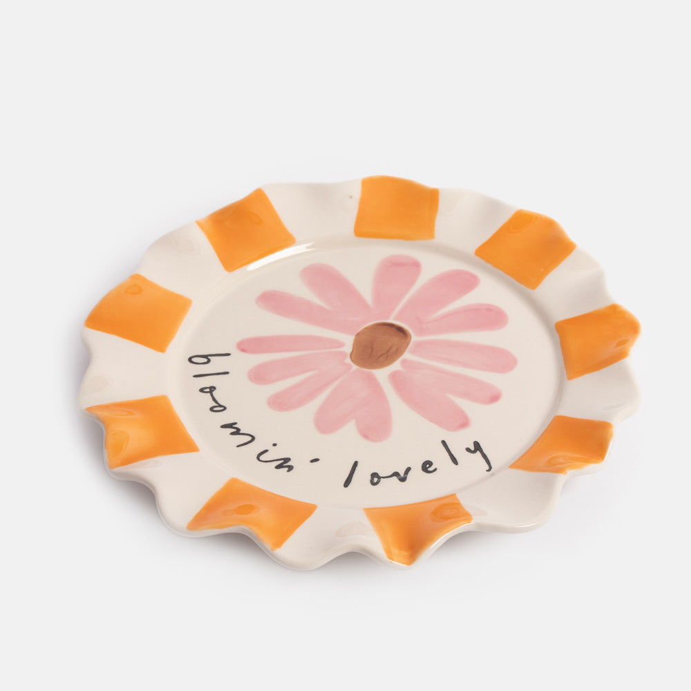 Ceramic plate with a pink flower illustration and 'bloomin' lovely' text on a white background