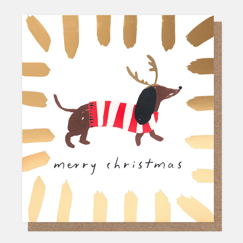 Christmas card with a dog in striped sweater and reindeer antlers on a white background with gold brush strokes.