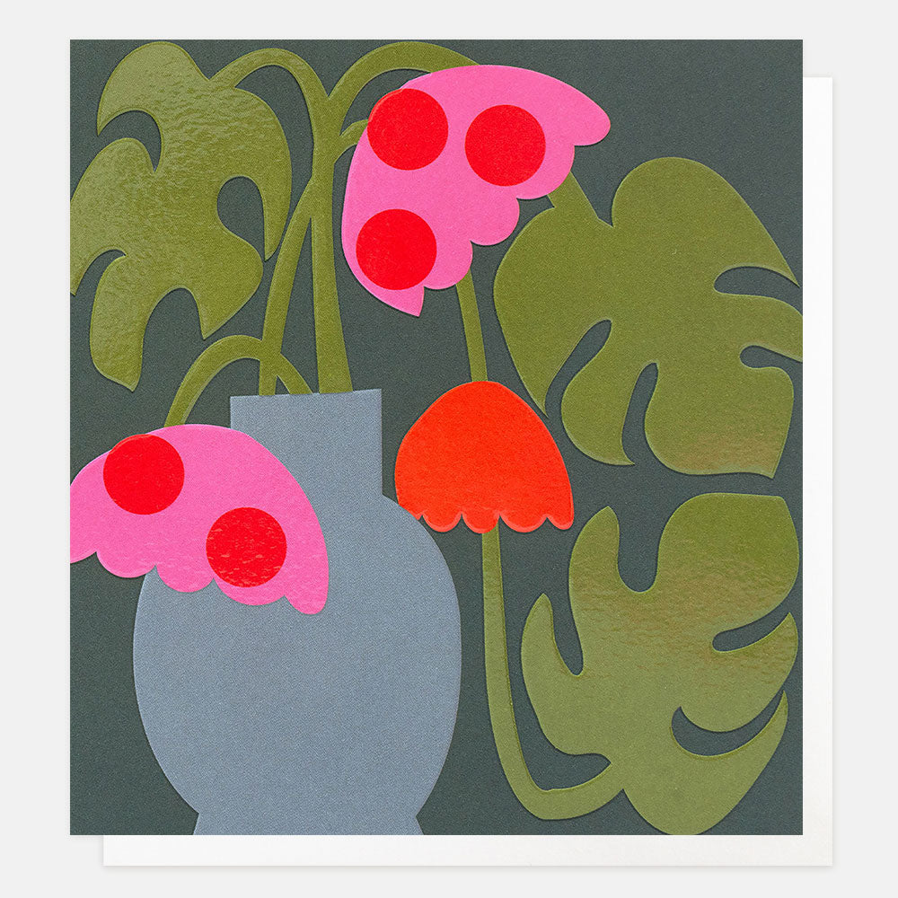 square greetings card featuring an illustration of a monstera plant with red & pink flowers and green leaves in a grey jug on a dark blue background