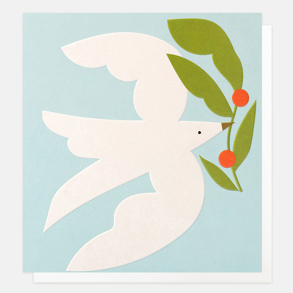A minimalist greetings card featuring a white dove in flight holding green leaves and small red berries against a light blue background.