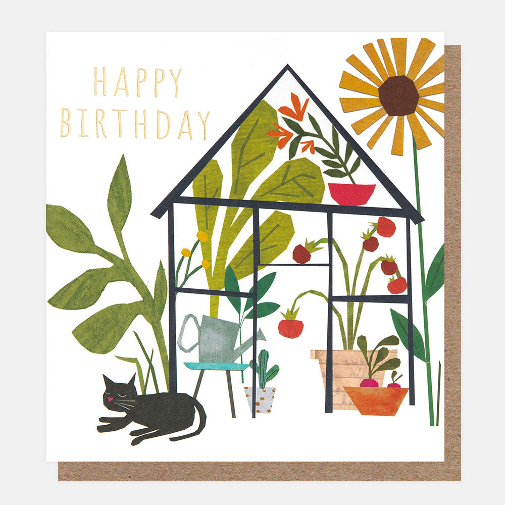 birthday card featuring a black cat lounging in front of a greenhouse with plants and tomatoes growing inside and a large sunflower.  